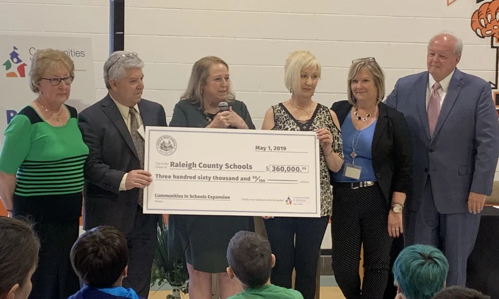 Group of people hold a large check