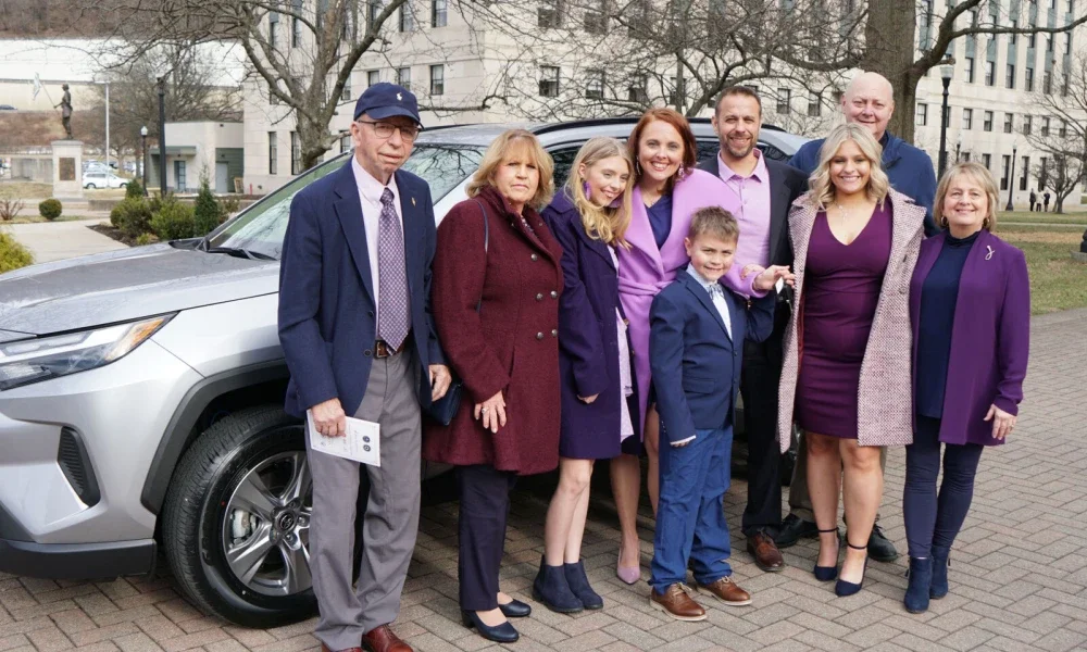 Amber Nichols (Teacher of the Year) and Family pictured in front of A car