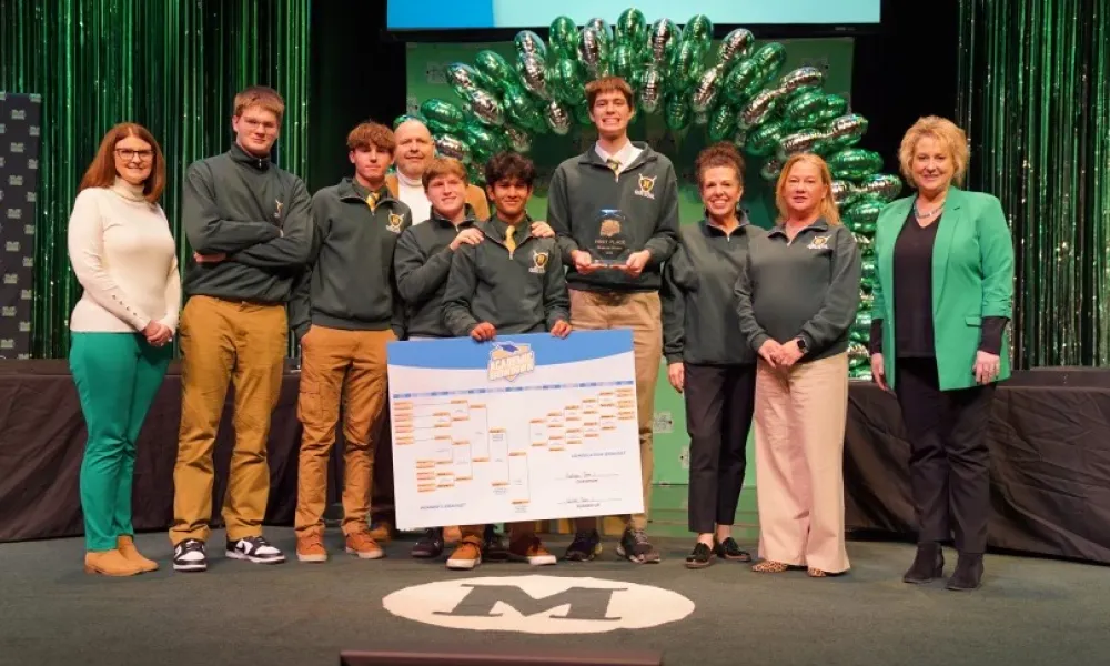 Group of Huntington High School students together with teachers celebrating win on stage