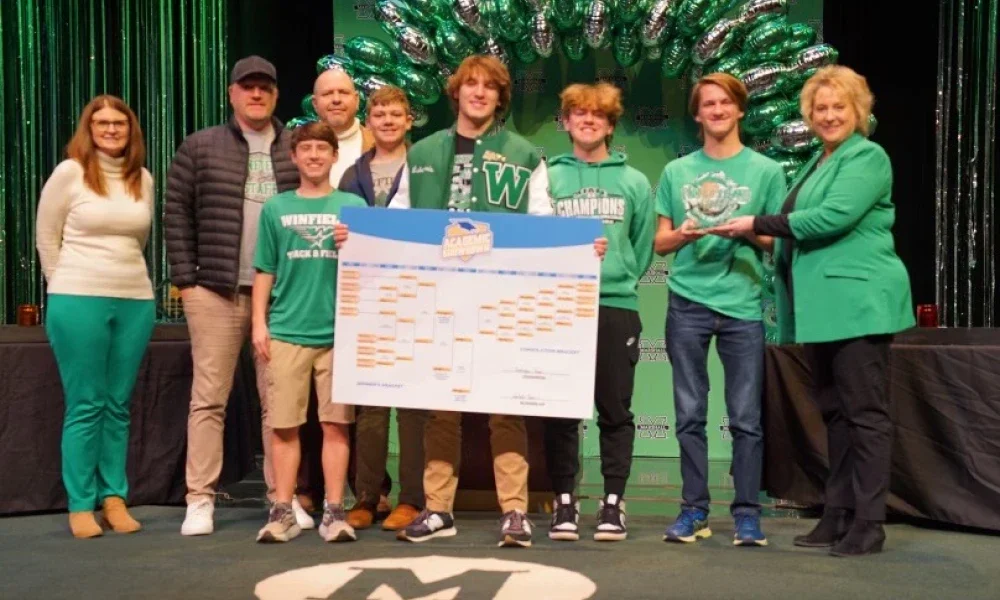 Group of Winfield High School students and teachers gathered together on stage to celebrate winning an event