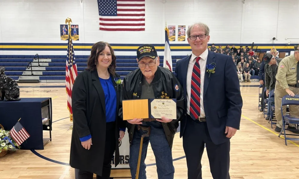 Phoebe Nichols, Charles Bird and Phil Dobbins pose for a photo with Bird’s high school diploma.