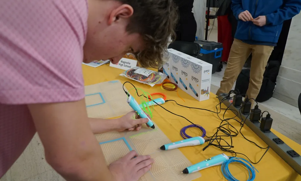 Person using a 3D pen to trace lines.