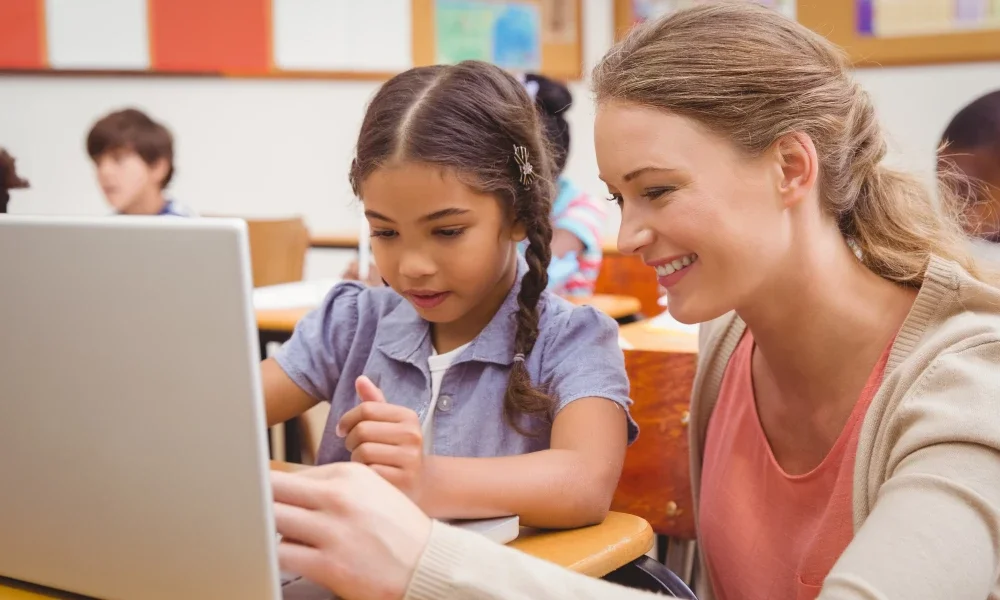 A child and an adult looking at a computer.