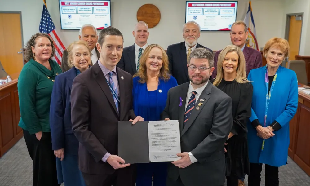 West Virginia Board of Education members, Educator Preparation Coordinator Robert Mellace, and Cabinet Secretary of the West Virginia Department of Veterans Assistance Ryan Kennedy pose for a photo.