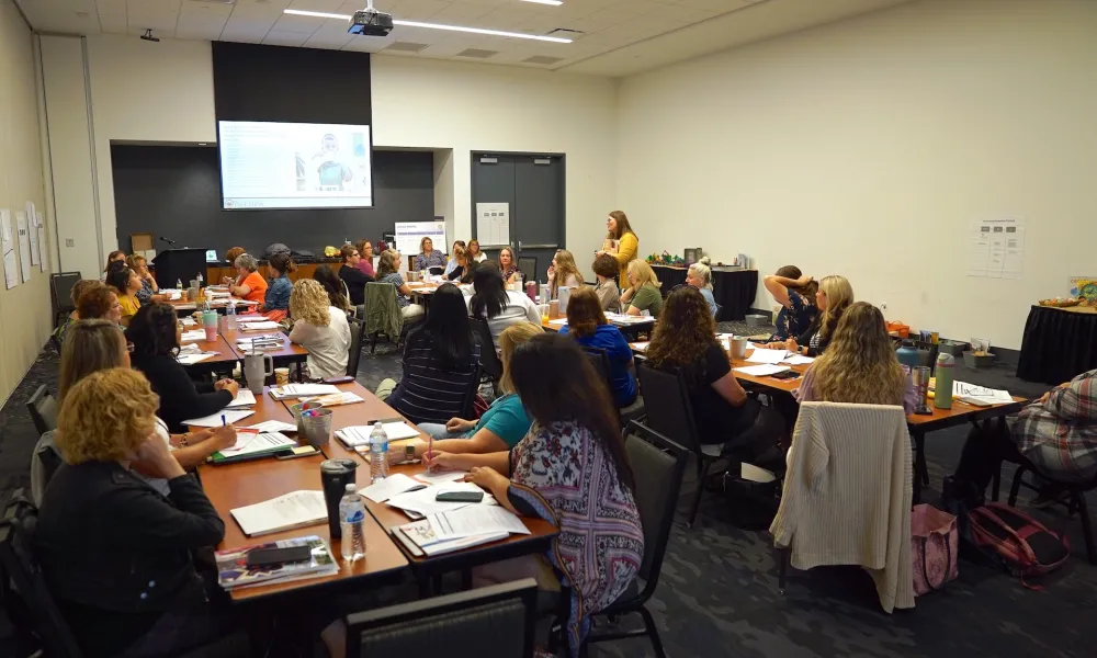 Group of people sitting at tables.