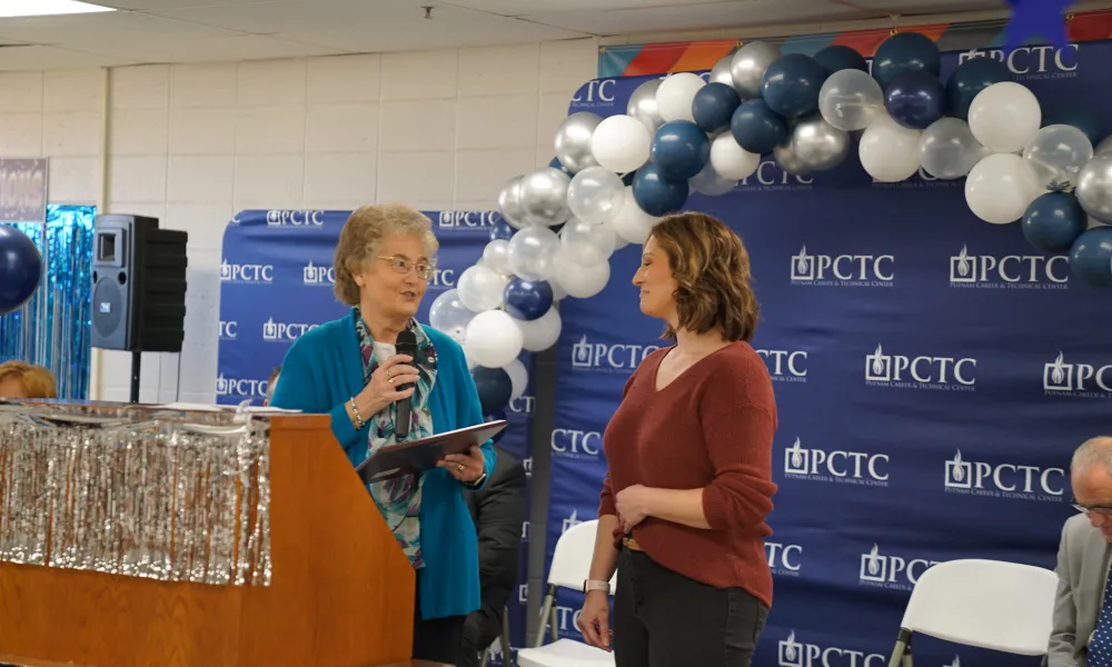 Two people standing on a stage.