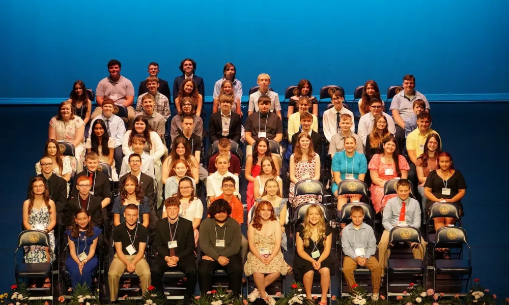 A group of students sitting in chairs on a stage.