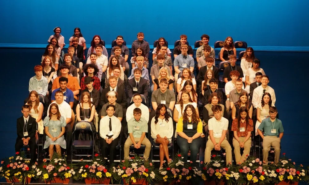 A group of students sitting in chairs on a stage.