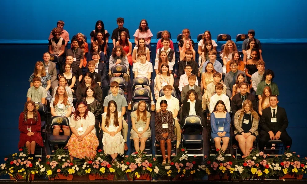 A group of students sitting in chairs on a stage.