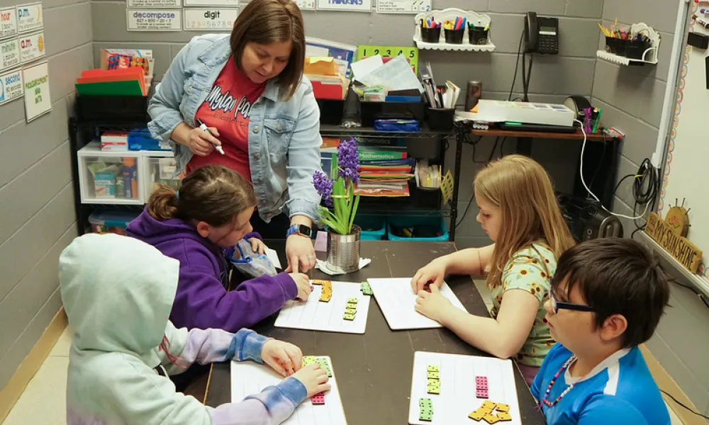 A teacher helping students with math.