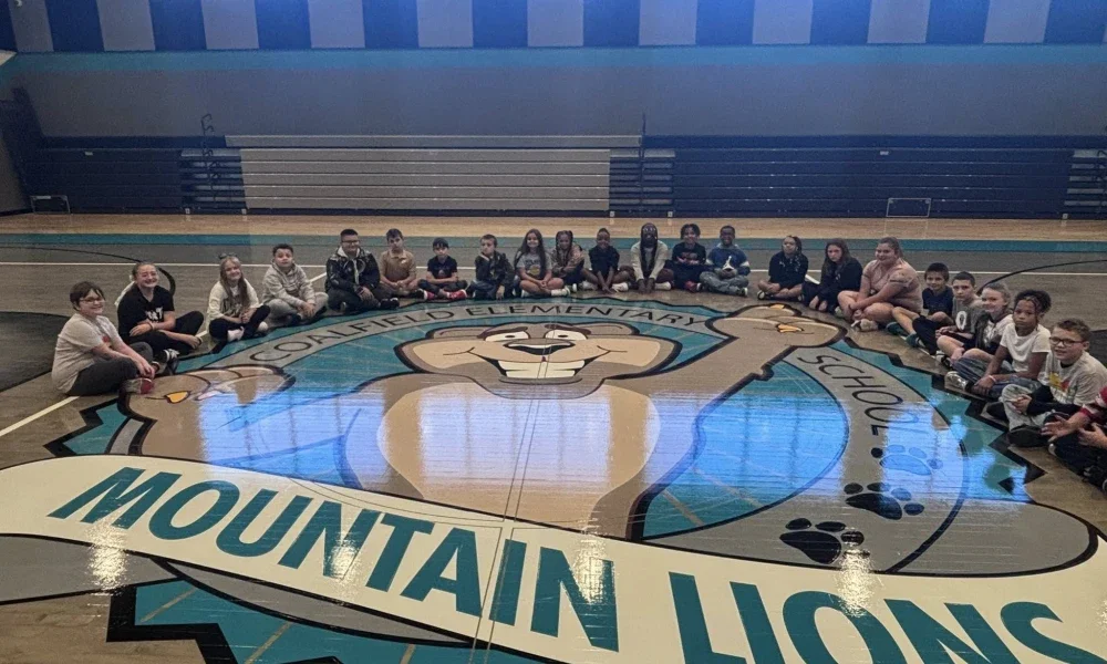 Students sitting on their school gymnasium floor. Mountain Lions.