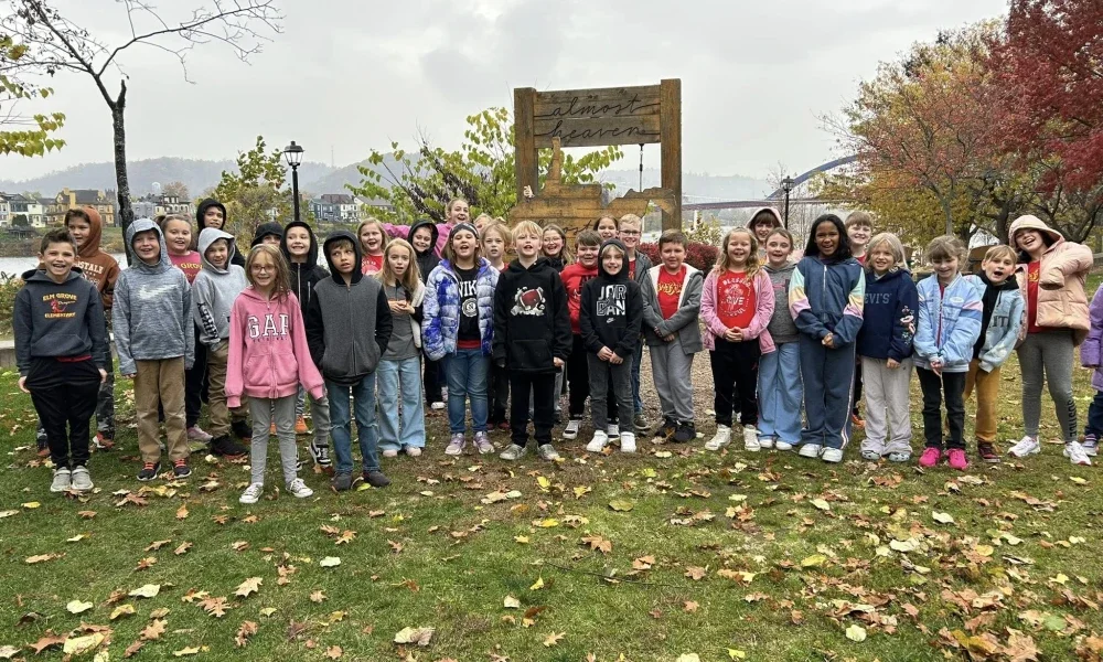 Students standing outside around a swing.