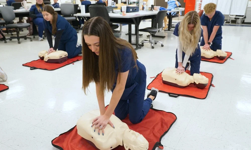 Students practicing CPR on a test dummy.