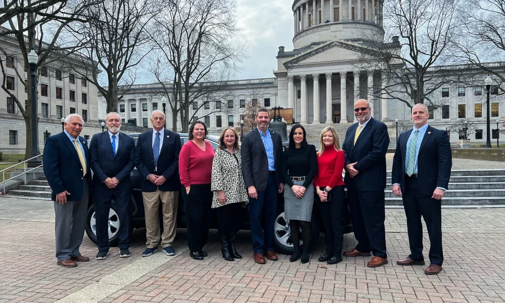 David Rosier, Tiffany Barnes, and West Virginia Board of Education members smiling while standing in front of a Toyota RAV4.