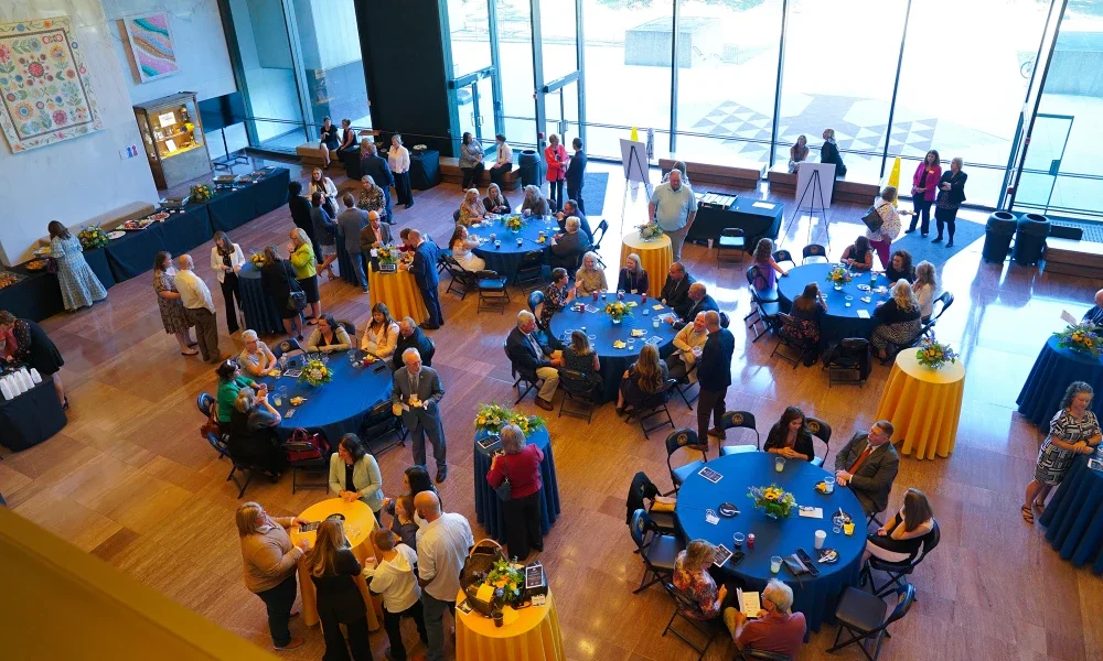 People sitting at tables enjoying refreshments at an award event
