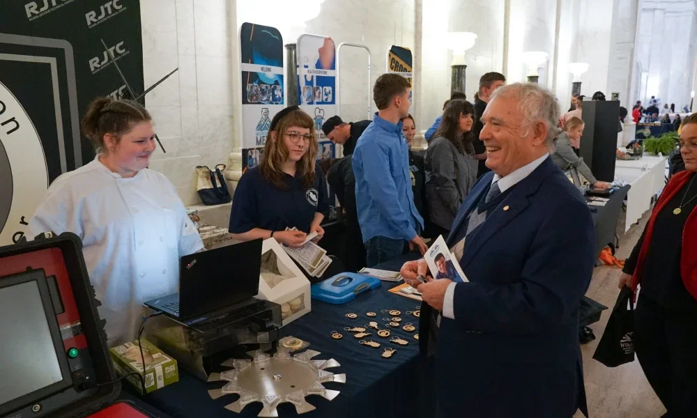 People laughing and smiling at a table inside the West Virginia State Capitol.