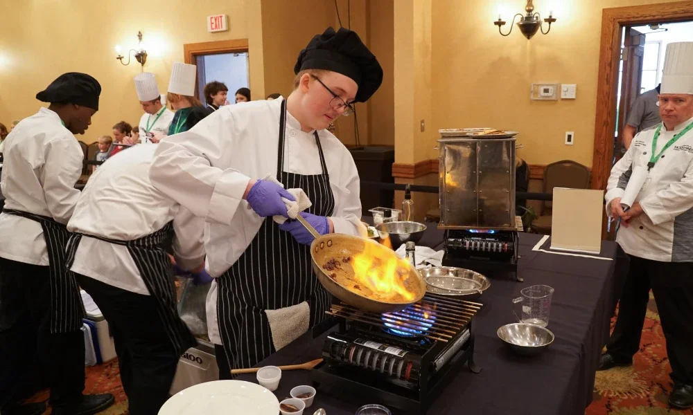 A student cooking over a burner.