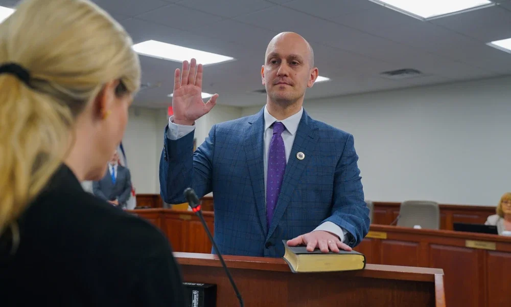 Dr. James Pauls holding his right hand up and placing his left on the Bible during his oath of office as the newest West Virginia Board of Education member.