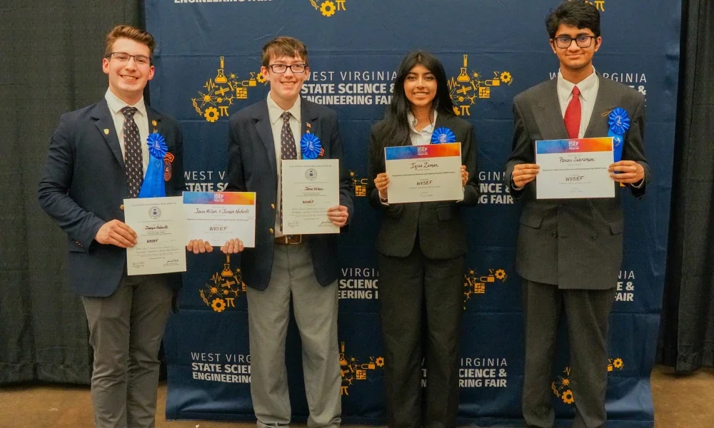 Joseph Nodurft, Jaxon Milam, Iqraa Zaman and Pavan Subramani smiling while holding certificates..