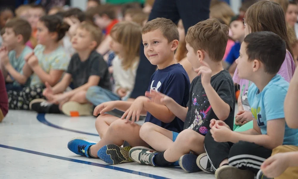 Students sitting on the floor and smiling