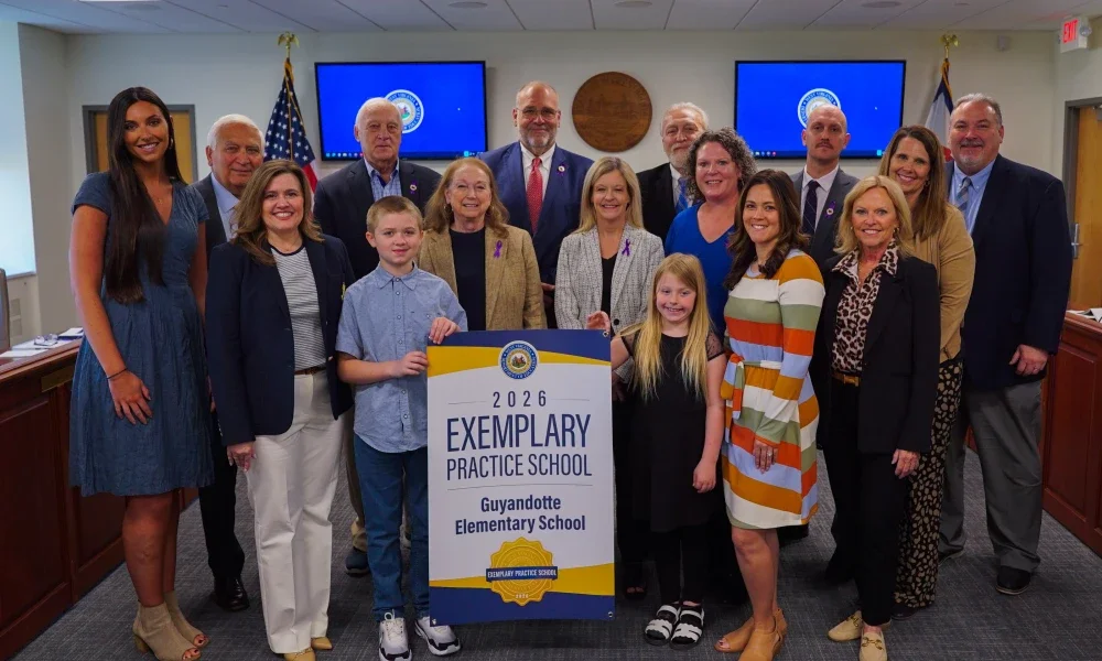 Members of Guyandotte Elementary and West Virginia Board of Education members smiling while holding an Exemplary Practice School banner.