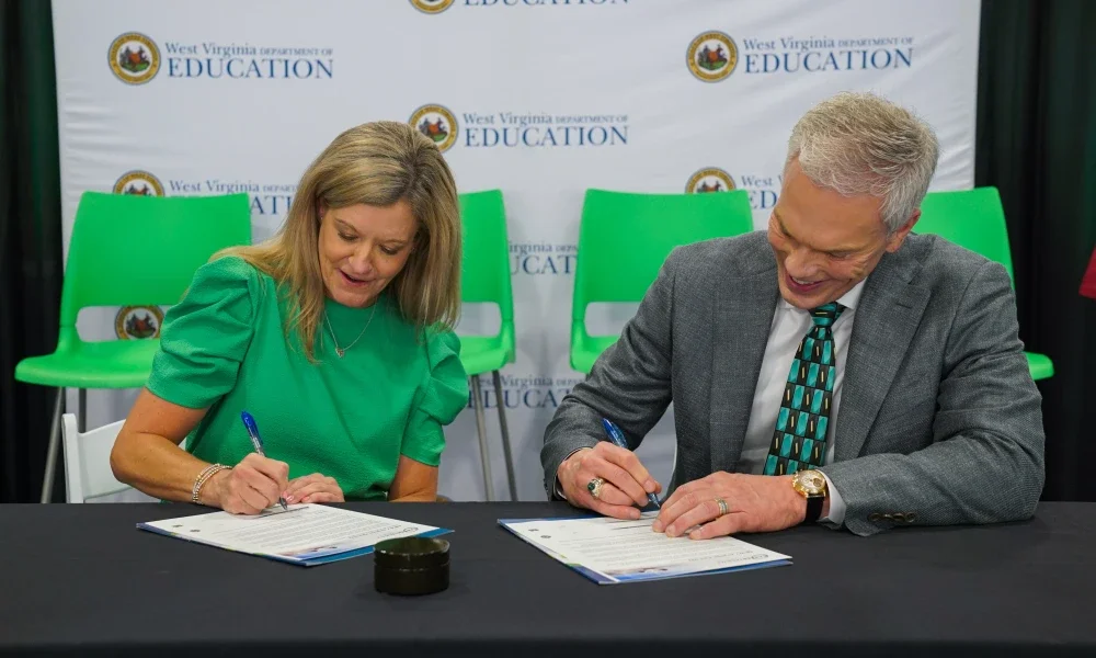 Michele Blatt and Brad Smith signing documents. 