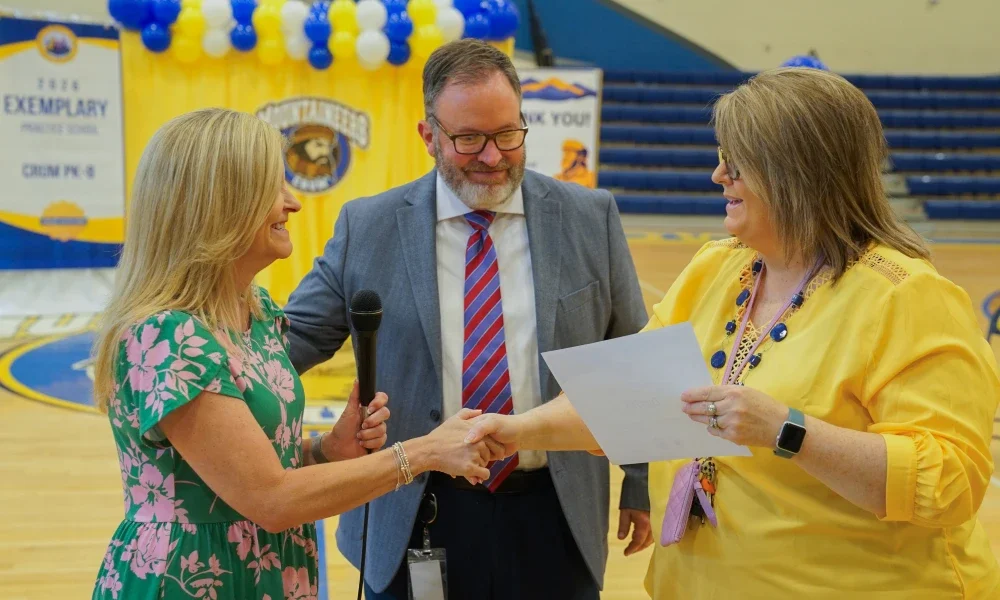 Michele Blatt shaking someone's hand while giving them a certificate. 