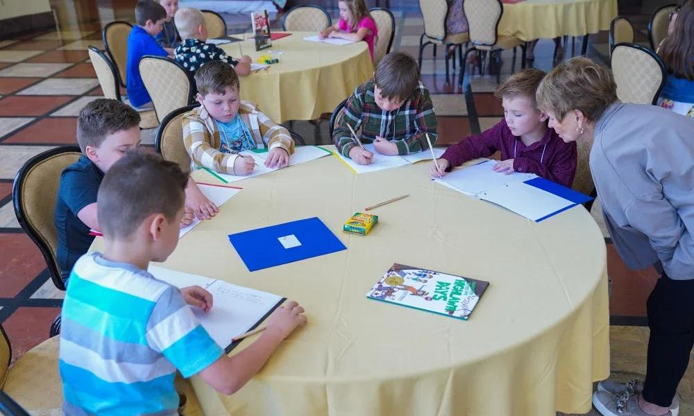 Students sitting at a table writing. 