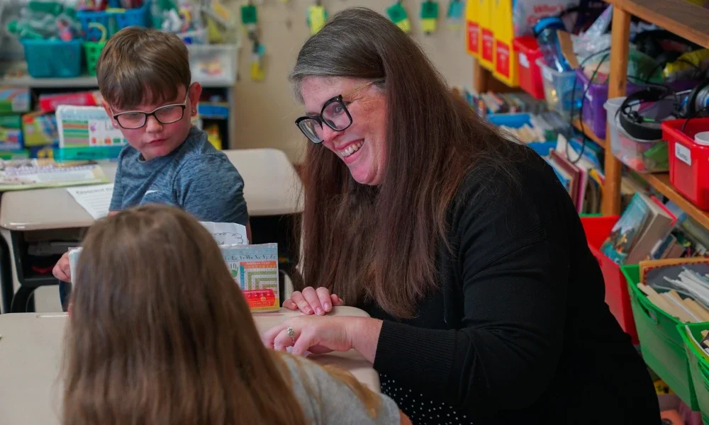 A school principal smiling at students. 