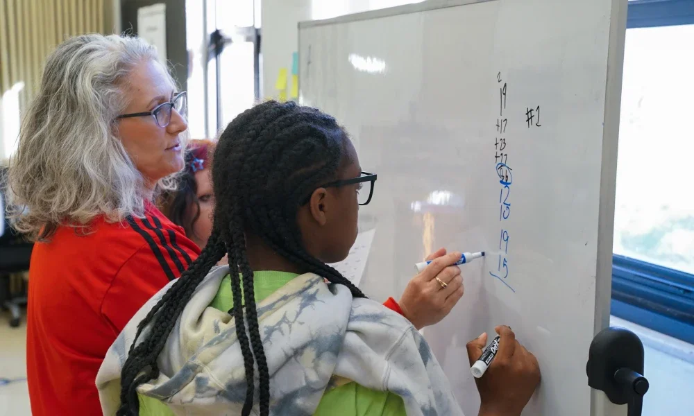 A teacher helping a student with math. 