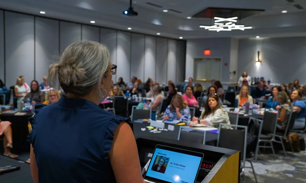 Dr. Erika Klose speaking to an audience from a podium. 