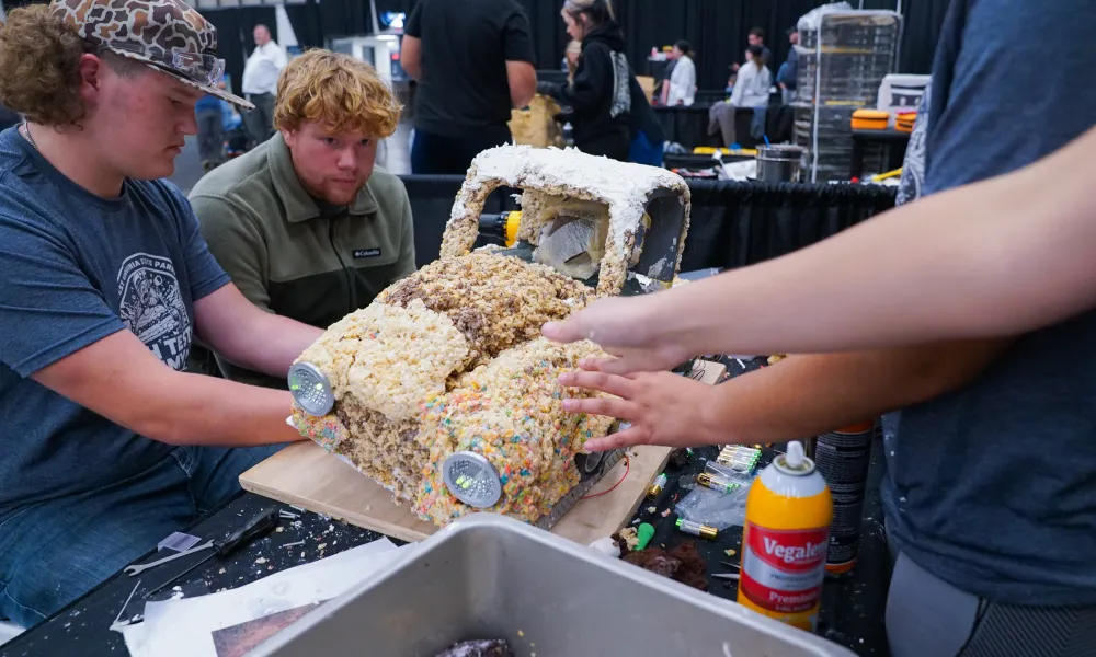 Students working on an edible structure shaped like a car. 