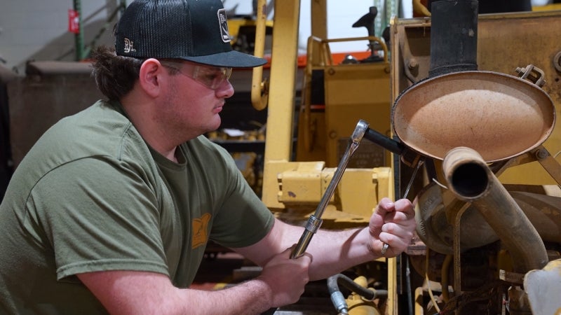 Man working on a motor with socket wrenches.