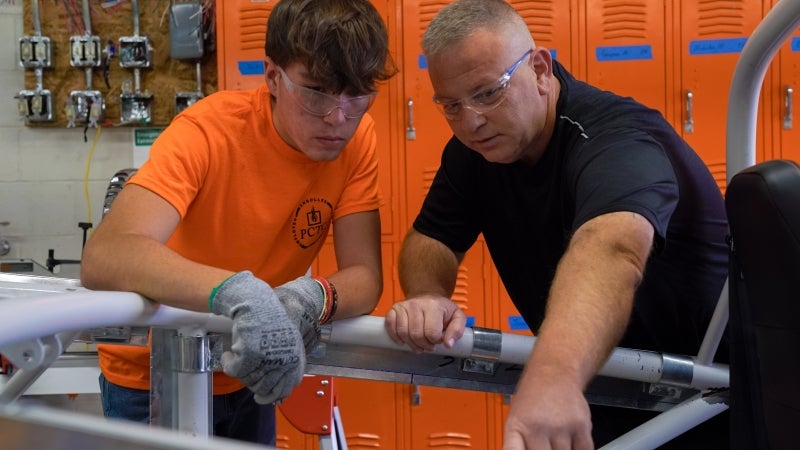 A teacher showing a student how to complete a task.