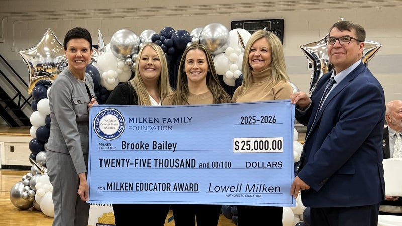 Brooke Bailey, Michele Blatt, and others holding a prize check for $25,000.