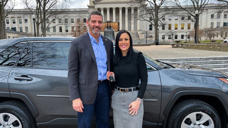 David Rosier and Tiffany Barnes smiling while standing in front of a Toyota RAV4.