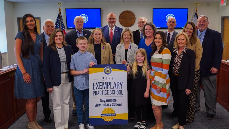 Members of Guyandotte Elementary and West Virginia Board of Education members smiling while holding an Exemplary Practice School banner.