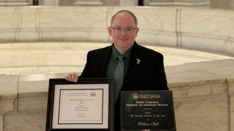 A person holding awards. 