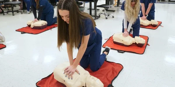 People practicing CPR on practice dummies.