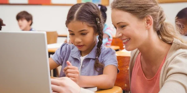 A child and an adult looking at a computer.