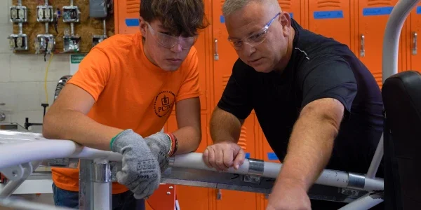 A career technical education instructor helping a student.