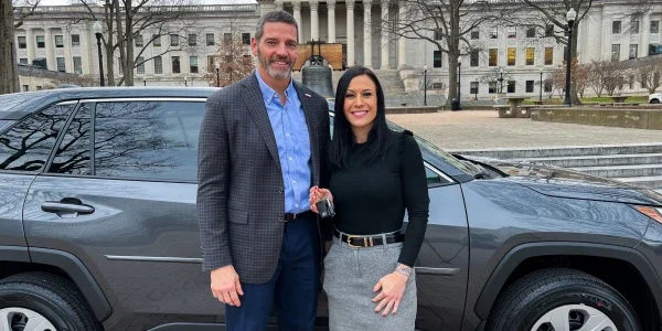 David Rosier and Tiffany Barnes smiling while standing in front of a Toyota RAV4.