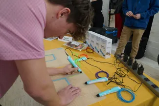 Person using a 3D pen to trace lines.