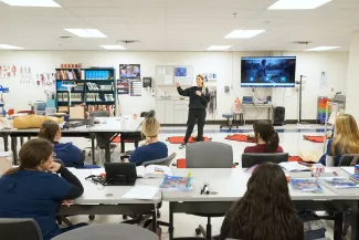 A woman teaching nursing students front the front of the classroom.