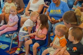 children smiling and sitting in chairs.