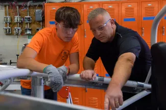 A teacher showing a student how to complete a task.