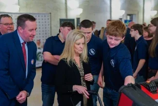 Michele Blatt interacting with a student project while receiving instruction from a student.