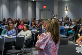 Kelly Griffith speaking to an audience while holding a microphone. 