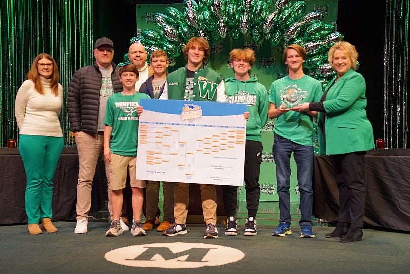 Group of Winfield High School students and teachers gathered together on stage to celebrate winning an event