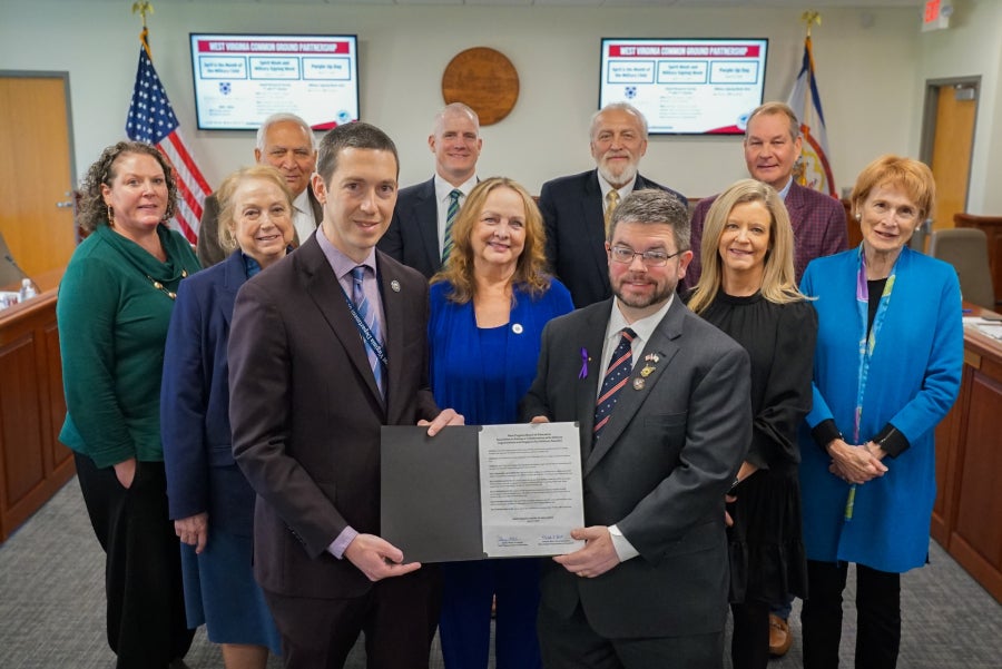 West Virginia Board of Education members, Educator Preparation Coordinator Robert Mellace, and Cabinet Secretary of the West Virginia Department of Veterans Assistance Ryan Kennedy pose for a photo.